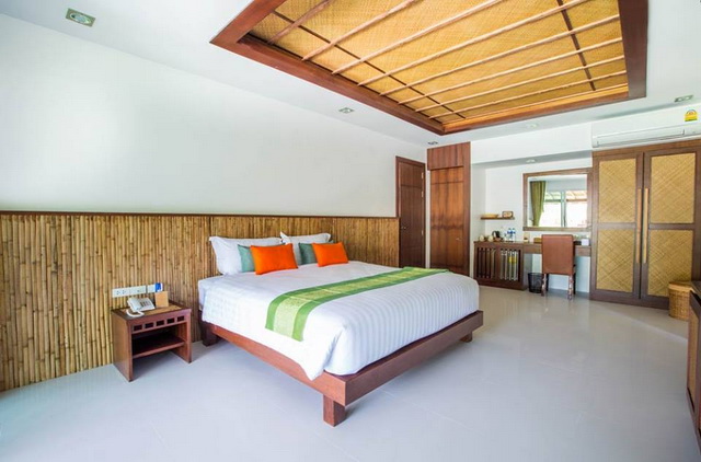 ห้องนอนพร้อมเตียง ตกแต่งผนังด้วยไม้ไผ่ในครึ่งด้านล่าง